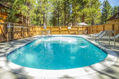 a swimming pool in a yard with a wooden fence at La Residence N3 in Mammoth Lakes