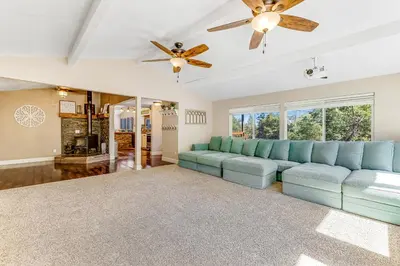 a living room with a blue couch and a ceiling fan at Wildcat Family Ranch in Murphys