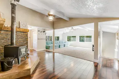 an open living room with a fireplace and a tv at Wildcat Family Ranch in Murphys