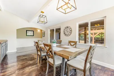 a dining room with a table and chairs and a clock at Wildcat Family Ranch in Murphys