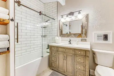 a bathroom with a sink and a toilet and a mirror at Wildcat Family Ranch in Murphys