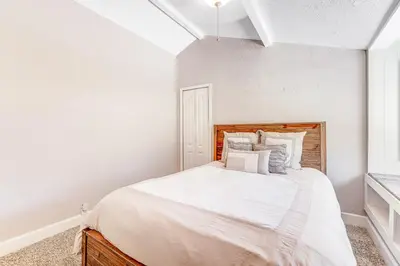 a white bedroom with a large bed and a window at Wildcat Family Ranch in Murphys