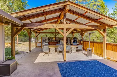 a wooden pavilion with a table and chairs on a patio at Wildcat Family Ranch in Murphys
