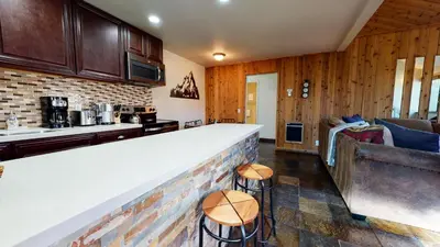a kitchen with a bar and a living room at San Sierra #26 condo in Mammoth Lakes