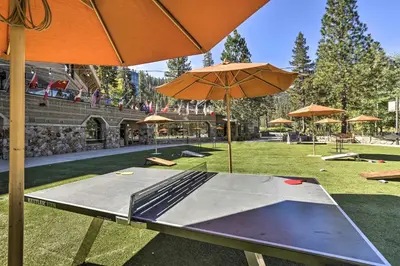 a ping pong table with an umbrella in a park at 6 Mi to Lake Tahoe Everline Resort Retreat! in Olympic Valley