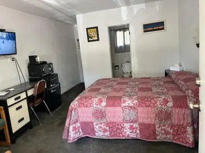 a bedroom with a bed and a desk and a computer at El Portal Motel in Beatty