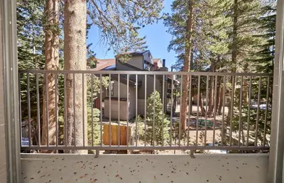 a view of a house from a balcony with trees at St Anton Wooded View 1-Bedroom Condos with Complimentary Hot Drinks in Mammoth Lakes