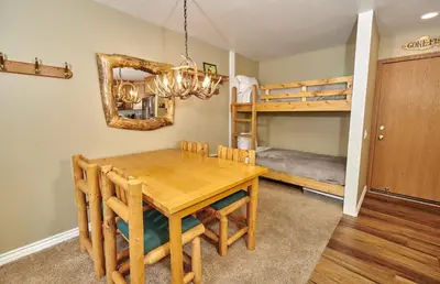 a dining room with a table and a bunk bed at St Anton Street View Ski-In & Out 1-Bedroom Condo in Mammoth Lakes