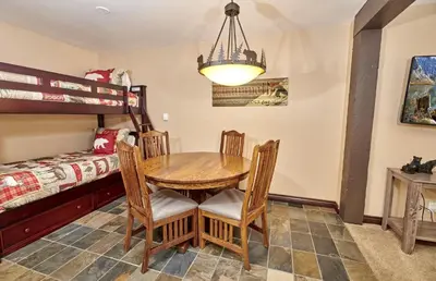 a dining room with a table and a bunk bed at St Anton Street View Ski-In & Out 1-Bedroom Condo in Mammoth Lakes