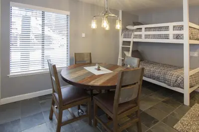 a dining room with a table and chairs and a bunk bed at St Anton Street View Ski-In & Out 1-Bedroom Condo in Mammoth Lakes
