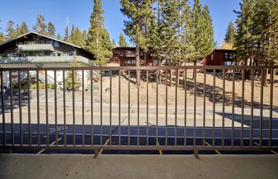 a fence in front of a house with a yard at St Anton Street View Ski-In & Out 1-Bedroom Condo in Mammoth Lakes