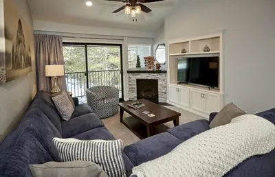 a living room with a blue couch and a tv at St Anton Courtyard View 2-Bedroom Condos with two oversized jacuzzi spas in Mammoth Lakes