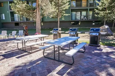 a group of picnic tables and benches in front of a building at St Anton Courtyard View 2-Bedroom Condos with two oversized jacuzzi spas in Mammoth Lakes