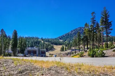 a building on the side of a road with trees at St Anton Condos with Rec Center in Mammoth Lakes