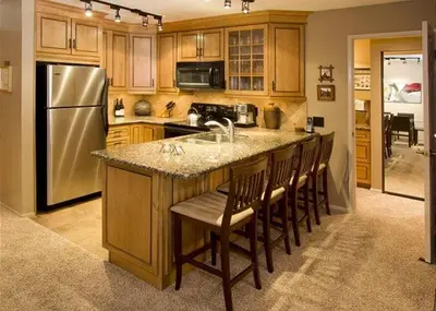 a kitchen with a island with a sink and a refrigerator at St Anton Street View 2-Bedroom Condo with full kitchen in Mammoth Lakes