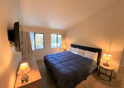 a bedroom with a large blue bed and two lamps at St Anton Courtyard View 2-Bedroom Condo with full kitchen in Mammoth Lakes