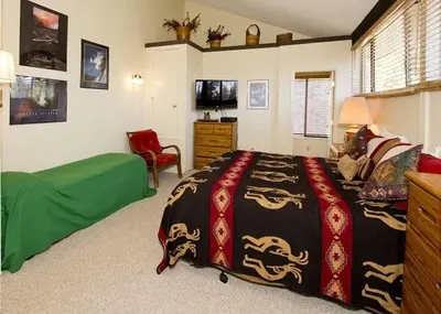 a bedroom with a bed and a chair at St Anton Courtyard View 2-Bedroom Condo with full kitchen in Mammoth Lakes