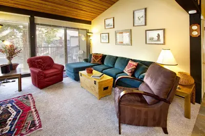 a living room with a blue couch and a chair at St Anton Courtyard View 2-Bedroom Condo with full kitchen in Mammoth Lakes