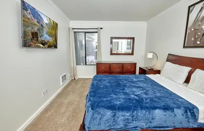 a bedroom with a blue bed and a window at St Anton Courtyard View 1-Bedroom Condos with Dry Sauna in Mammoth Lakes
