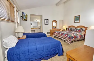 a hotel room with two beds and a table at St Anton Courtyard View 2-Bedroom Condos with Pool & Jacuzzi in Mammoth Lakes