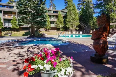 a statue of a bear and flowers in front of a pool at St Anton Wooded View 2-Bedroom Condos with Ski Lockers in Mammoth Lakes