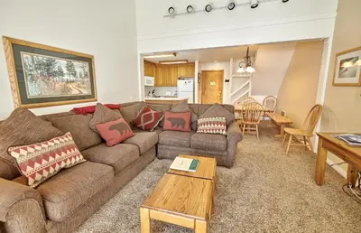 a living room with a couch and a table at St Anton Wooded View 2-Bedroom Condos with Ski Lockers in Mammoth Lakes