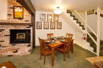 a dining room with a table and a fireplace at St Anton Wooded View 2-Bedroom Condos with Ski Lockers in Mammoth Lakes