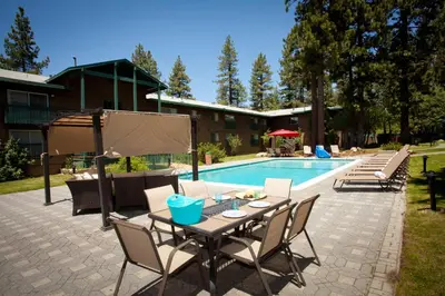 a patio with a table and chairs next to a pool at Forest Suites Resort at the Heavenly Village in South Lake Tahoe