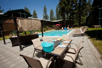a patio with a table and chairs next to a pool at Forest Suites Resort at the Heavenly Village in South Lake Tahoe