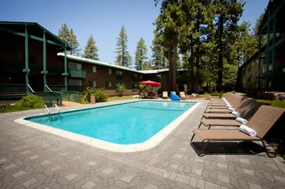 a swimming pool with lounge chairs and a hotel at Forest Suites Resort at the Heavenly Village in South Lake Tahoe