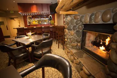 a restaurant with a fireplace and a table and chairs at Forest Suites Resort at the Heavenly Village in South Lake Tahoe