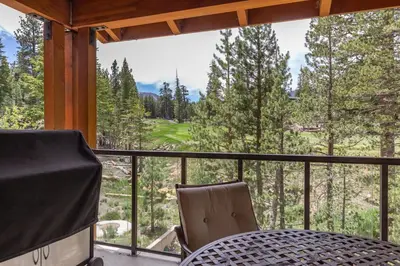 a table and chairs on a balcony with a view at Woodwinds #1265 townhouse in Mammoth Lakes