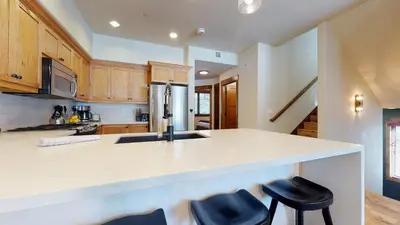 a kitchen with a counter and two stools in it at Woodwinds #1265 townhouse in Mammoth Lakes