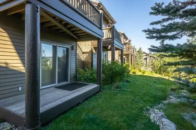 a house with a wooden porch and a yard at Snowcreek V 963 in Mammoth Lakes
