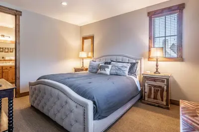 a bedroom with a bed with blue sheets and a window at Lodges 1138 in Mammoth Lakes