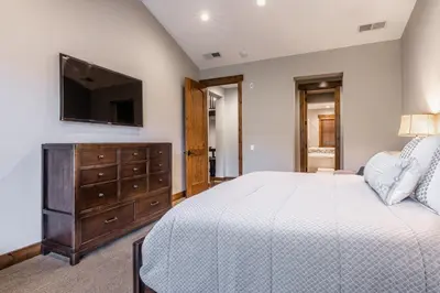 a bedroom with a bed with a dresser and a tv at Lodges 1138 in Mammoth Lakes
