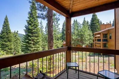a balcony with two chairs and a view of the woods at Northstar - Gold Bend Getaway in Truckee