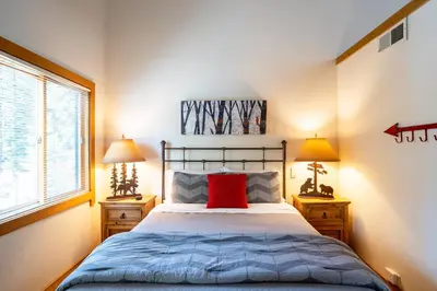 a bedroom with a bed with a red pillow and two lamps at Northstar - Gold Bend Getaway in Truckee