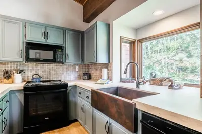 a kitchen with green cabinets and a sink at Helios 9N in Mammoth Lakes
