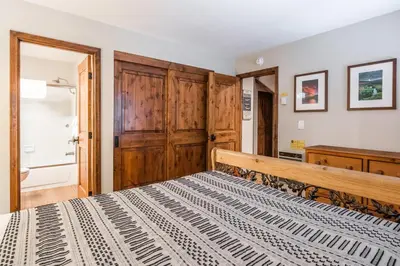 a bedroom with a bed and a wooden cabinet at Helios 9N in Mammoth Lakes