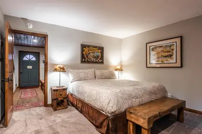 a bedroom with a bed and a table and a door at Helios 9N in Mammoth Lakes
