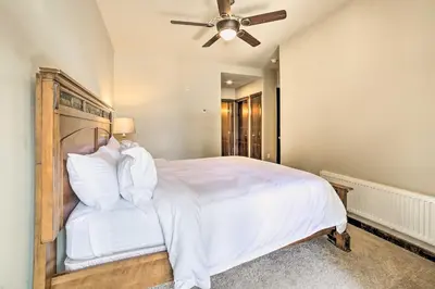 a bedroom with a large white bed with a ceiling fan at Modern Mammoth Lakes Condo Ski, Hike, and More! in Mammoth Lakes