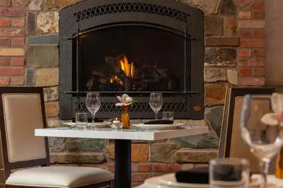 a fireplace in a restaurant with a table with wine glasses at National Hotel Jackson, Tapestry Collection by Hilton in Jackson