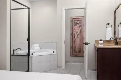 a white bathroom with a tub and a sink at National Hotel Jackson, Tapestry Collection by Hilton in Jackson