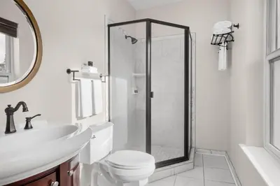 a bathroom with a shower and a toilet and a sink at National Hotel Jackson, Tapestry Collection by Hilton in Jackson
