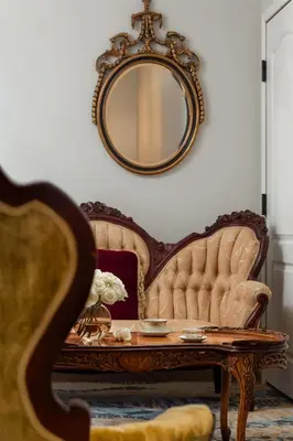 a living room with a couch and a mirror at National Hotel Jackson, Tapestry Collection by Hilton in Jackson