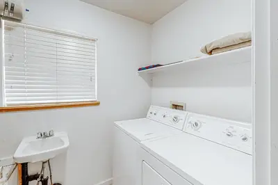 a white laundry room with a washing machine and a sink at Grey Fireplace in Truckee