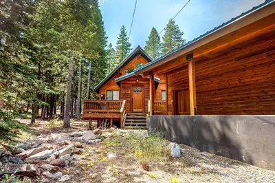 a log cabin in the woods with a porch at Grey Fireplace in Truckee