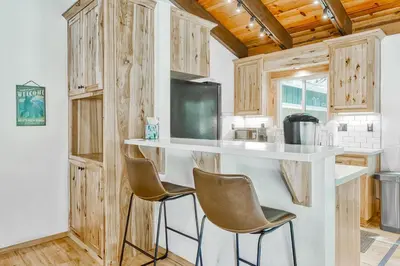 a kitchen with a counter and chairs in a room at The Lazy Golden Cabin in South Lake Tahoe