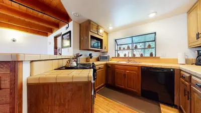 a kitchen with wooden cabinets and a black appliances at Snowflower #20 condo in Mammoth Lakes